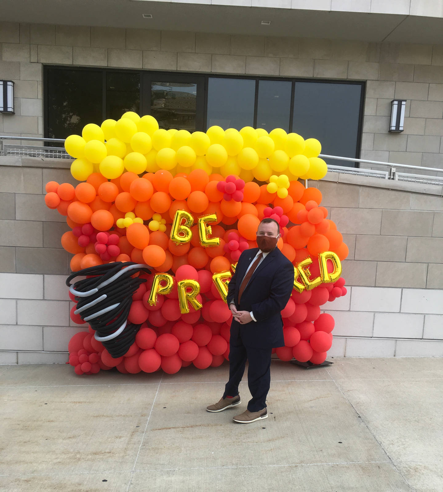 Commissioner Justin Aldred poses for a photo in front of the Be Prepared balloon wall while visiting the vendors and learning more about preparedness.